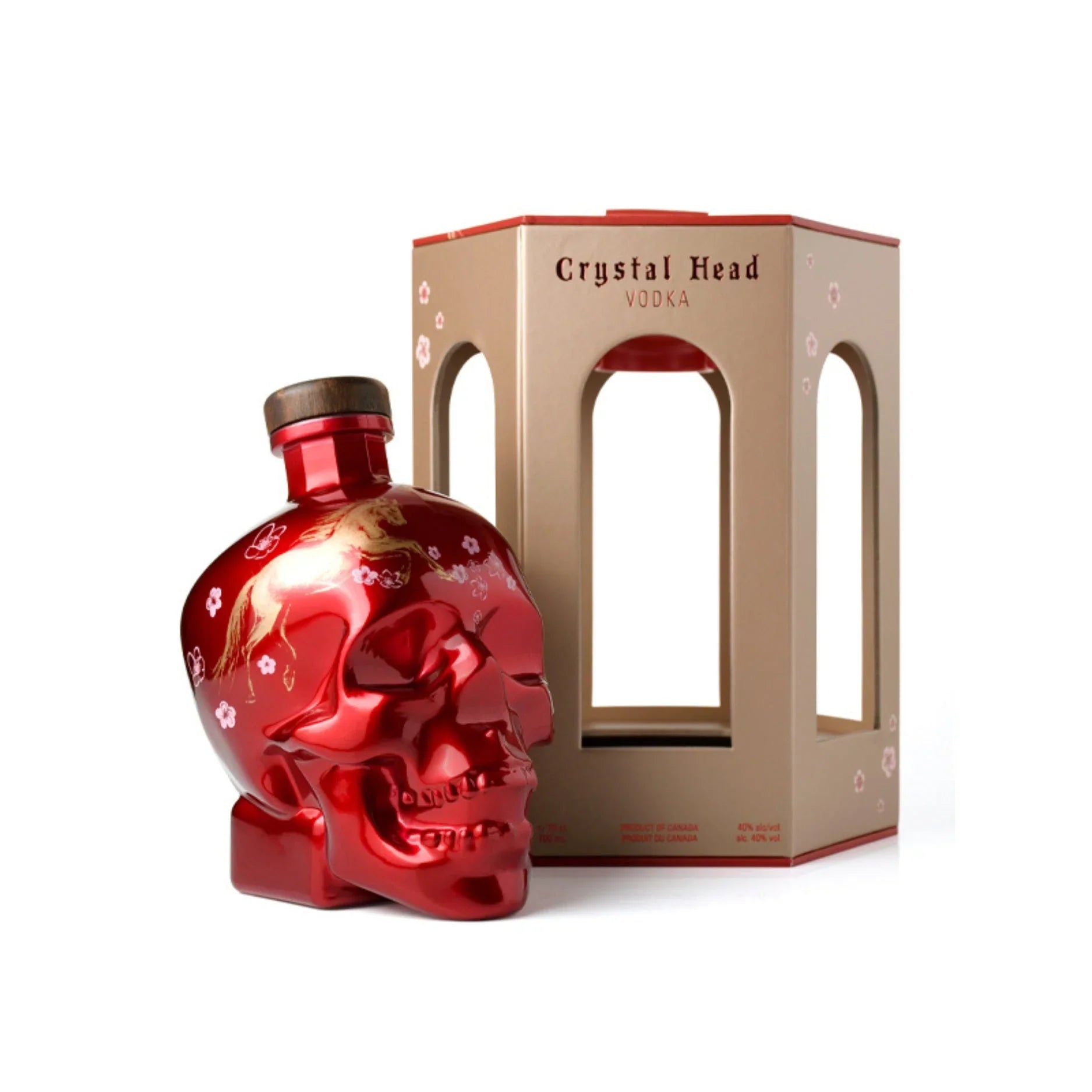 A shiny red Crystal Head Vodka Year of the Horse 2026 Lunar New Year Limited Edition skull bottle with floral designs and a wooden cap stands by a beige-and-red box with cut-out windows, both displayed on a white background.