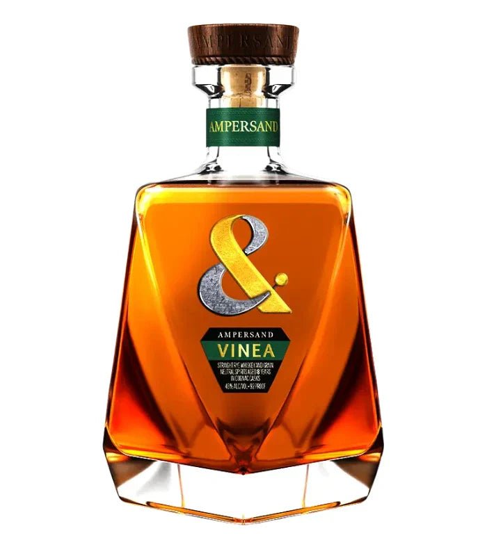 A 750mL bottle of Ampersand Vinea 8 Year Old Rye Whiskey, featuring a golden-brown spirit in a distinct glass decanter with an amber liquid, green label, wooden cap, and a large gold ampersand on the front.