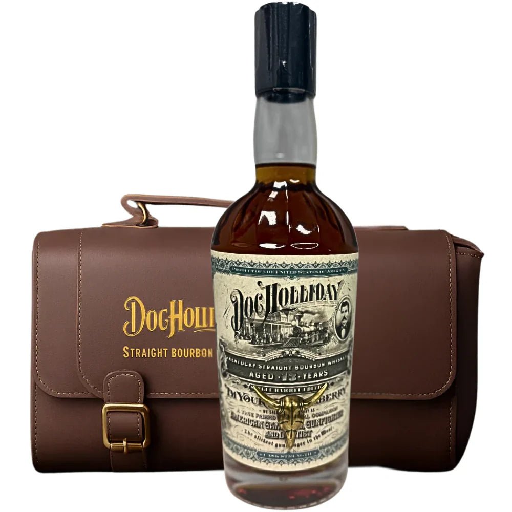 A bottle of Doc Holliday 13 Year Doctor's Bag Single Barrel Bourbon sits before a brown leather carrying case labeled "Doc Holliday Straight Bourbon Whiskey.