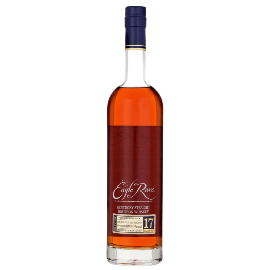 A bottle of Eagle Rare 17 Year Old Bourbon Whiskey 2025 Release from Eagle Rare, featuring a tall clear glass body, navy blue cap, and gold and white label, filled with dark amber Kentucky straight bourbon.