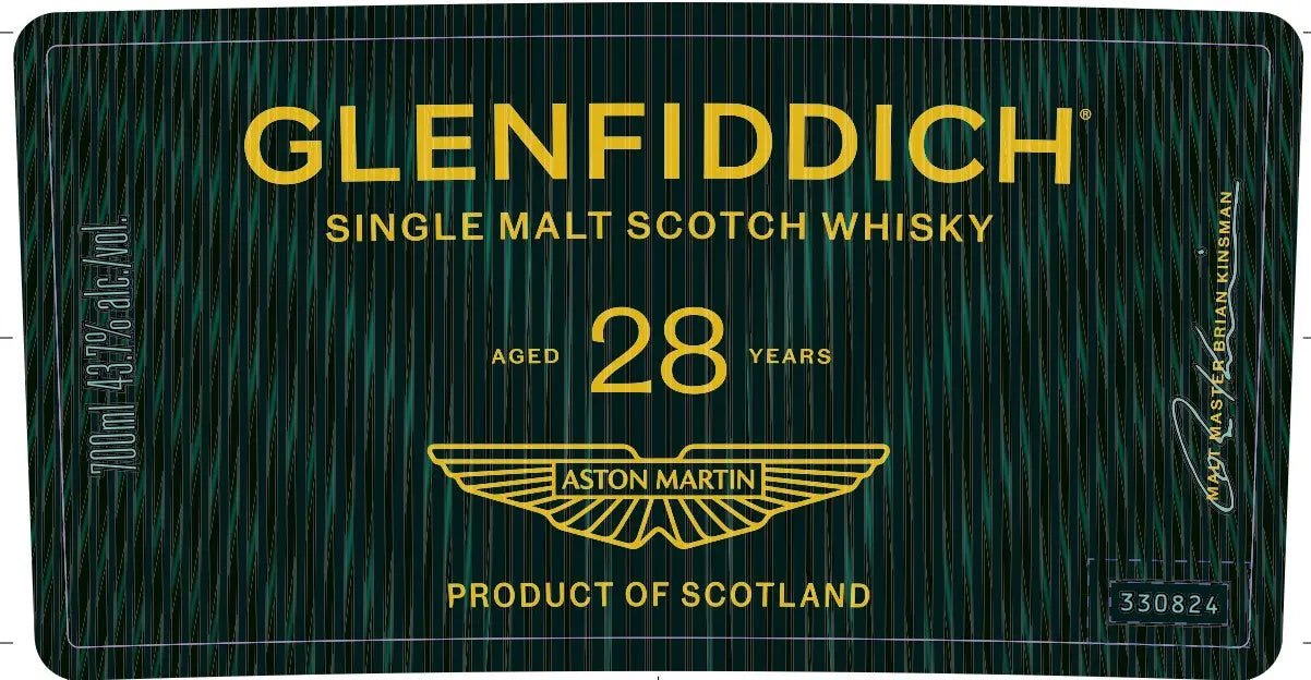 Label for Glenfiddich 28 Year Aston Martin Single Malt Scotch Whisky 700mL, showcasing gold lettering and logo, prominent Glenfiddich and Aston Martin branding, and "Product of Scotland" displayed on a green patterned backdrop.