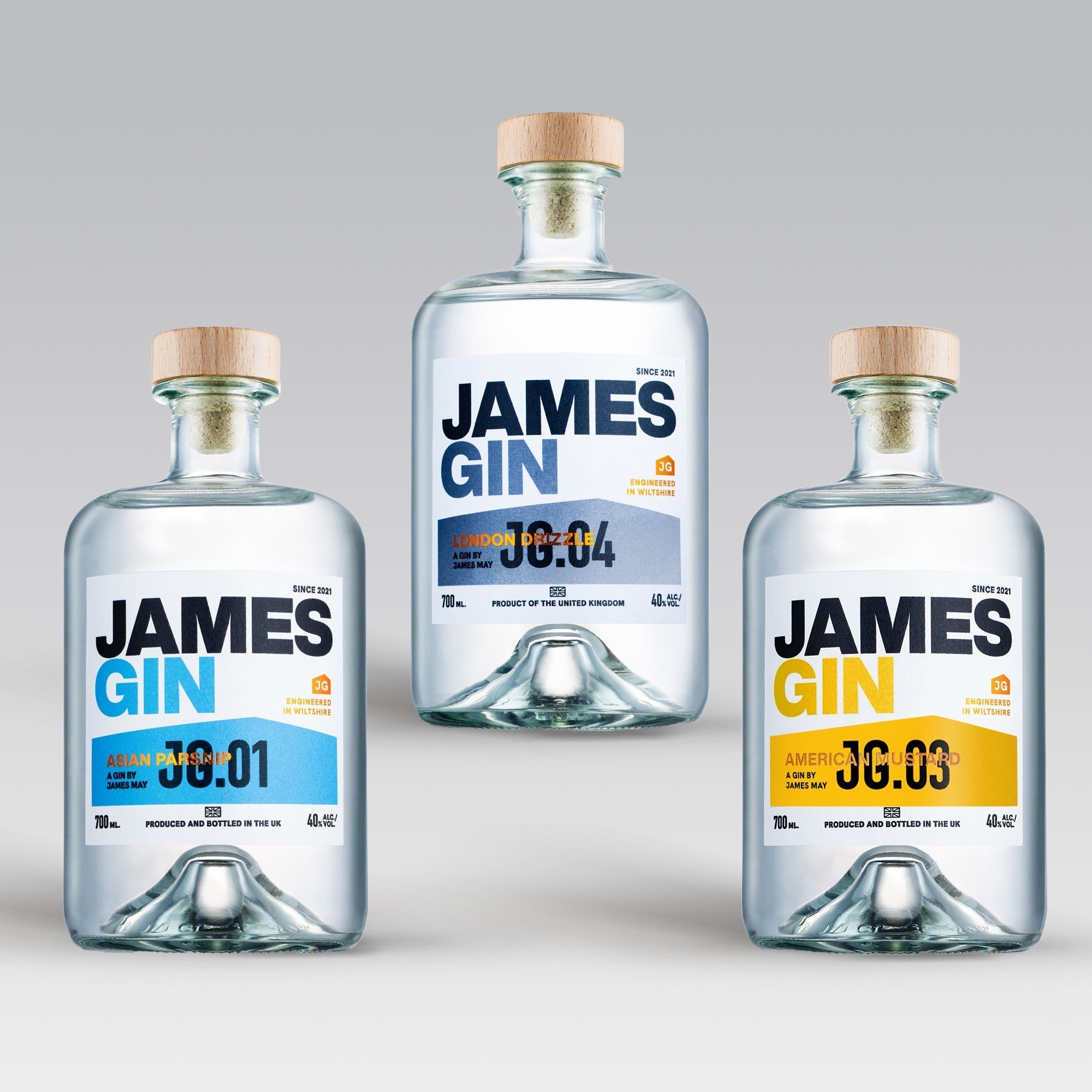 The James Gin The Power of Three Bundle W/ Souvenir Gift Key Chain features three British craft gins—Asian 36:01, London 36:04, and American 36:03—each in a bottle with a wooden cap and clear liquid against a light gray backdrop.