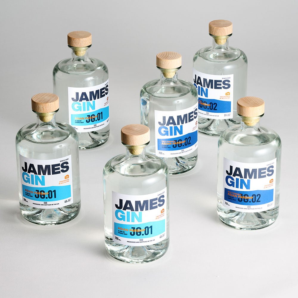 Six clear glass bottles of James Gin US The Six Pack Asian Parsnip & Navy Strength, each with wooden caps and white labels, are arranged on a light surface. Includes two batch numbers (36:01 & 36:02) and a souvenir gift key chain.