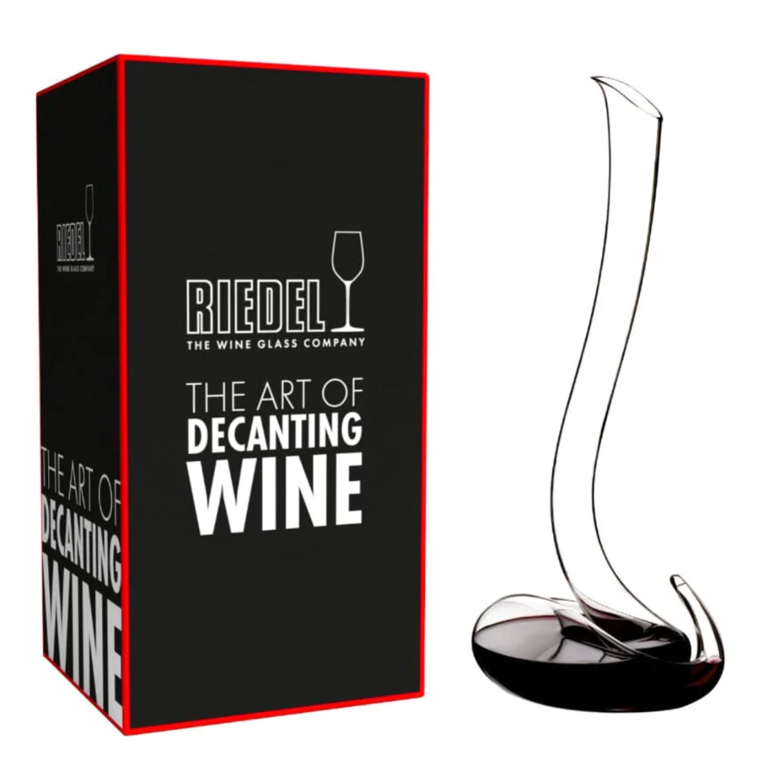 A Riedel Wine Decanter Eve with a tall, elegantly curved neck sits beside its black and red box labeled "Riedel: The Art of Decanting Wine," exemplifying the exceptional wine aeration achieved by this exquisite crystal decanter from Riedel.