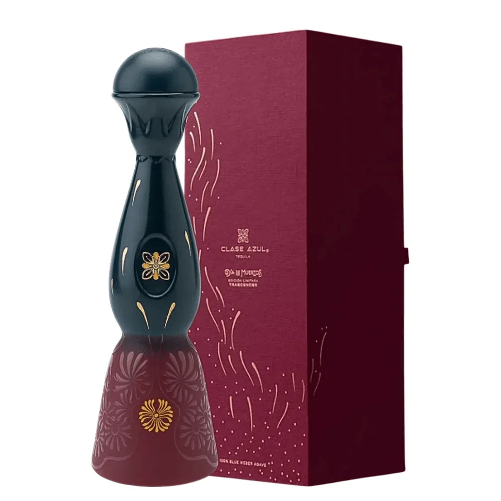 A tall, dark, decorative Clase Azul Día de Muertos Trascender 2026 Limited Edition Añejo Tequila 1L decanter with a rounded top and a flared base, featuring gold floral accents, standing next to a matching burgundy presentation box.