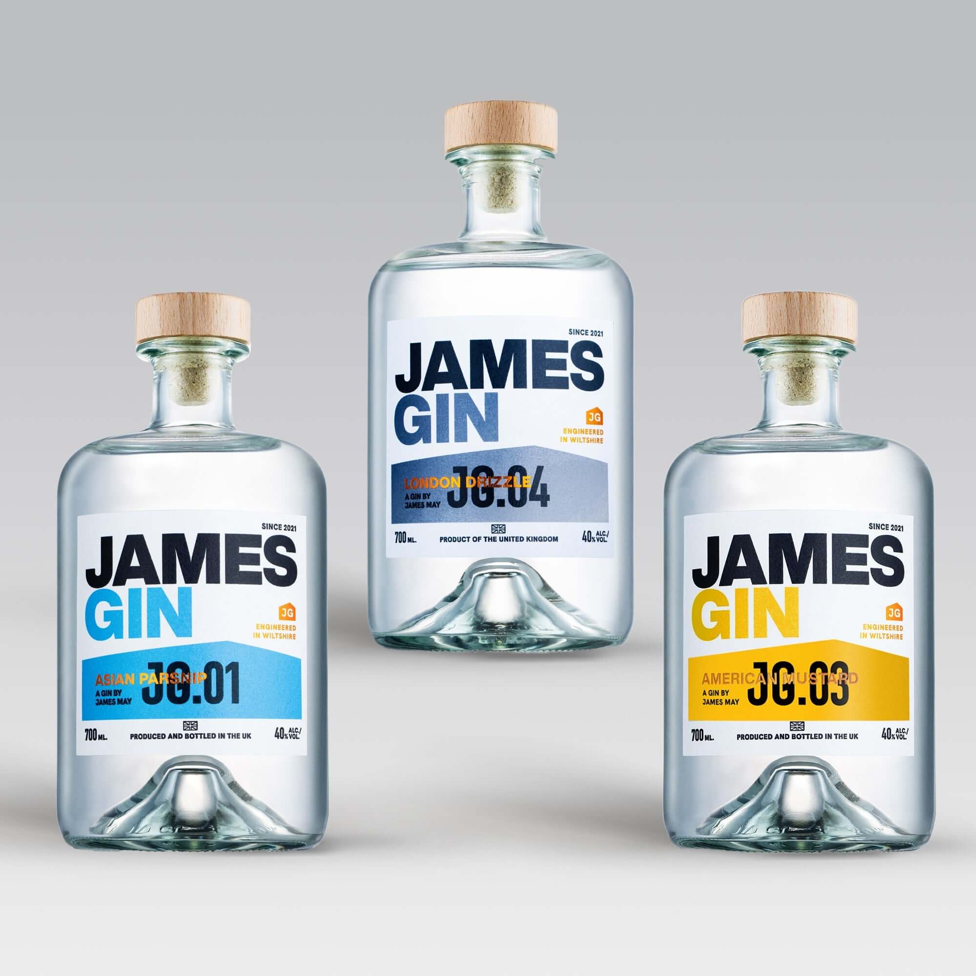 The James Gin The Power of Three Bundle W/ Souvenir Gift Key Chain features three British craft gins—Asian 36:01, London 36:04, and American 36:03—each in a bottle with a wooden cap and clear liquid against a light gray backdrop.