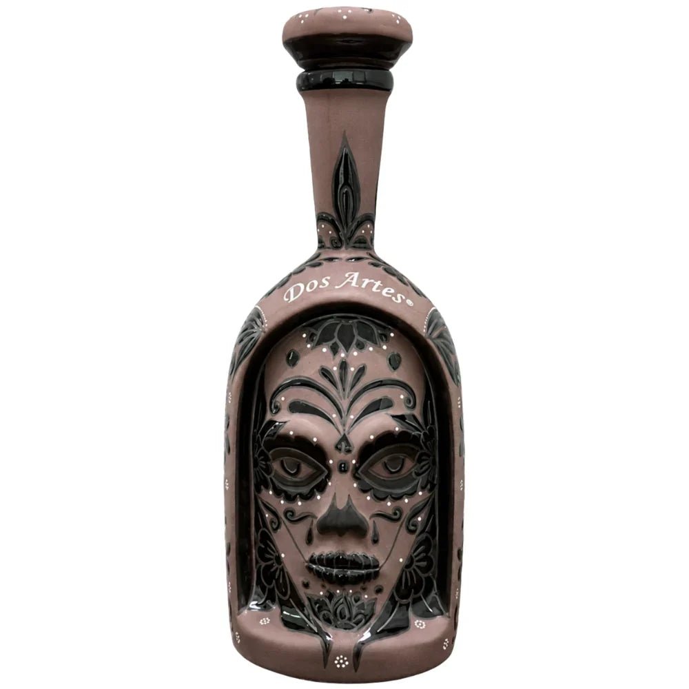 A stunning Dos Artes Día de los Muertos Calavera Extra Añejo Reserva Especial 36 Limited Edition 2026 (Pre-Order) tequila bottle by Dos Artes features a brown finish adorned with an intricate black and white skull face, elaborate patterns, and floral motifs on the front. This remarkable collectible vessel houses Extra Añejo tequila, making it a standout centerpiece for any enthusiast’s collection.