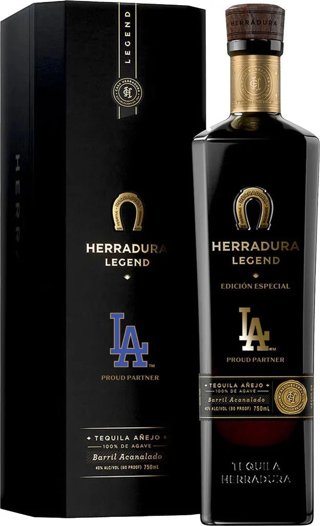 A bottle of Herradura Legend LA Dodgers Añejo Tequila and its black box packaging, both adorned with gold and blue Los Angeles Dodgers logos and text marking a special partnership. The label highlights this as a special edition, 100% agave, 750ml premium sipping tequila from Herradura Tequila crafted to celebrate the LA Dodgers.
