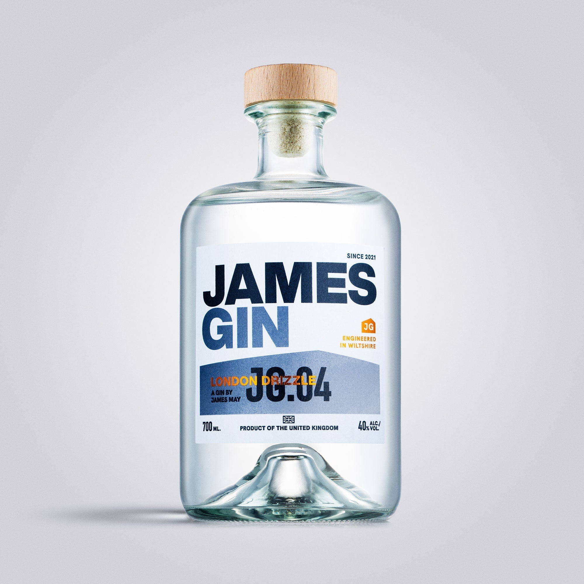 A clear 700mL glass bottle of James Gin London Drizzle (80 Proof) with a wooden cap and white label featuring bold blue and orange accents. Includes a souvenir gift key chain. Artisan gin by James Gin, product of the United Kingdom.