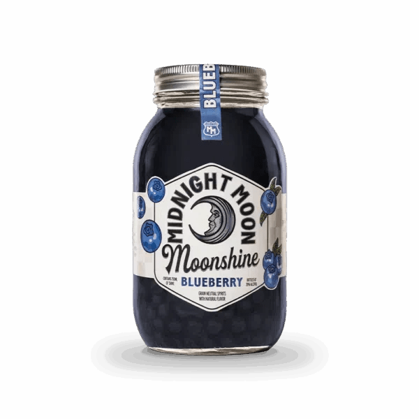 A clear mason jar of Midnight Moon Blueberry Moonshine by Midnight Moon Moonshine has a crescent moon and blueberries on the label, a sealed silver lid, and a small blue tag. The dark blue moonshine is visible inside.