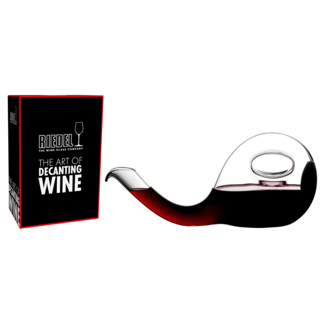 A curvaceous, crystal RIEDEL Wine Decanter Escargot filled with red wine, its unique pipe-like shape displayed beside a black and red box labeled "Riedel The Art of Decanting Wine," showcases the elegance of wine aeration.