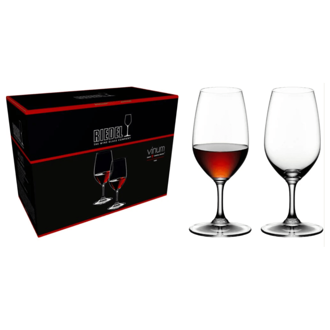 A box labeled "RIEDEL Wine Glass Vinum Port Set of 2" by Riedel is placed next to two elegant crystal stemware glasses—one filled with red wine and the other empty—set against a pristine white background.